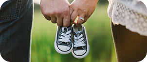 close up of a couple holding a pair of baby shoes